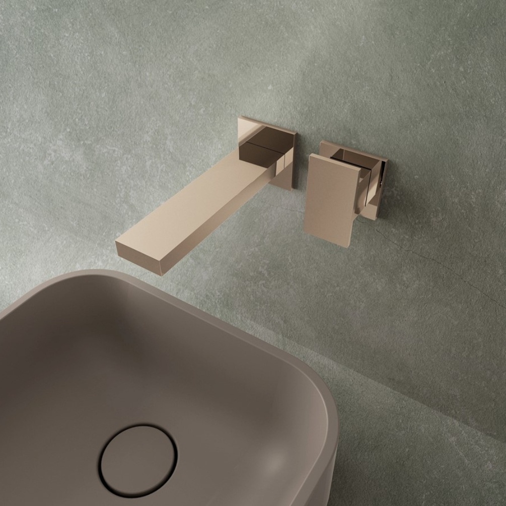 Lifestyle image of the Crosswater Myron Chrome Wall Mounted Basin Mixer installed on a grey bathroom wall above a square-shaped countertop basin